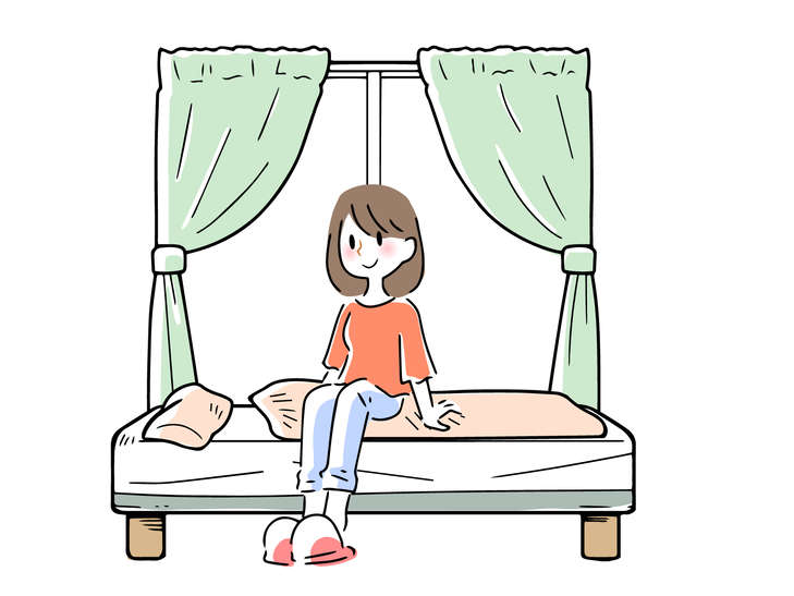 窓辺のベッドに座る女性